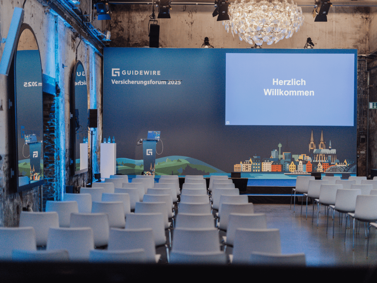 Guidewire Versicherungsforum 2025 im Harbour Club Köln – moderne Tagungslocation mit Bühne und Sitzreihen.