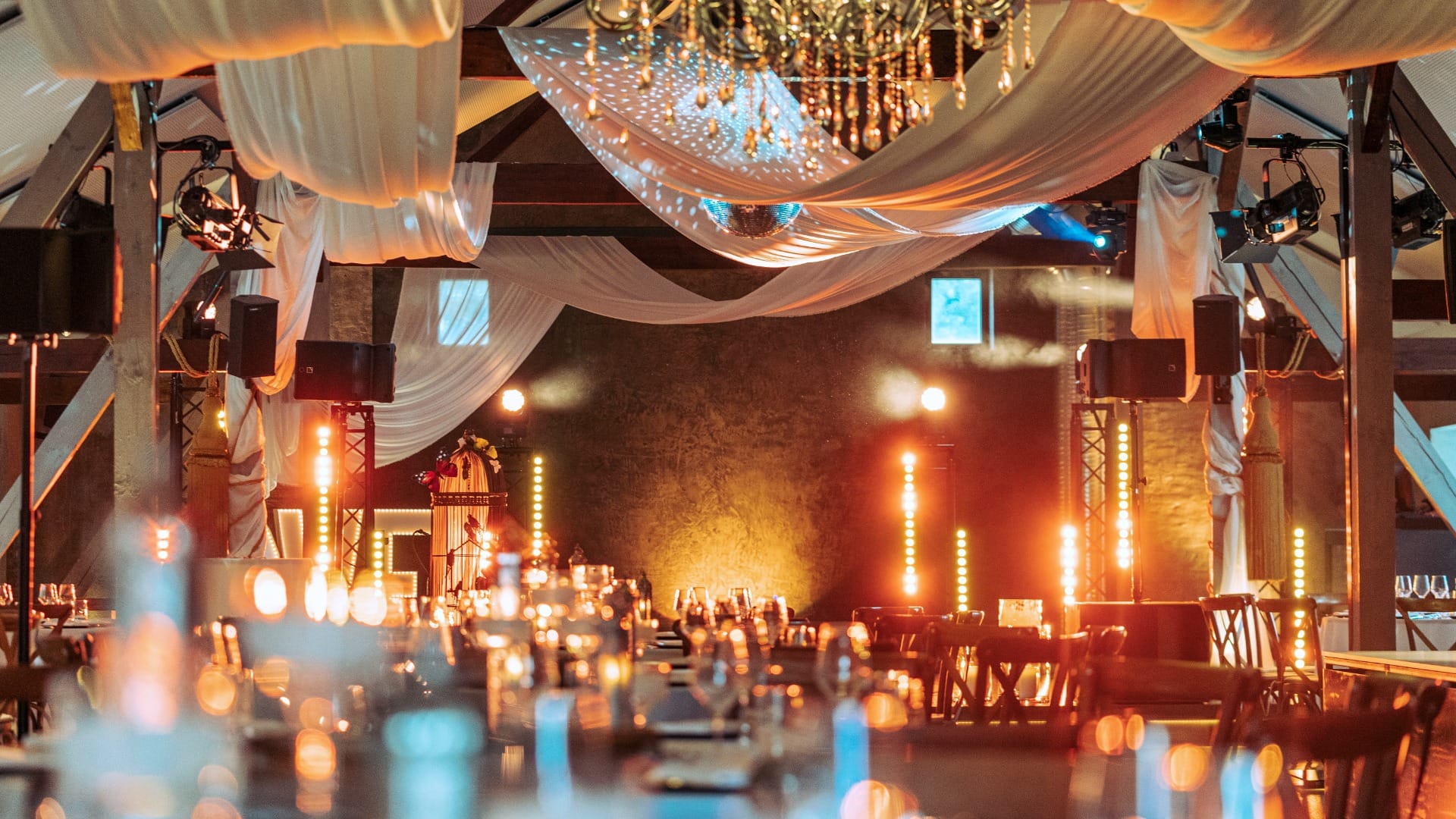 Eleganter Festsaal mit stimmungsvoller Beleuchtung, Spiegelkugel und orientalischen Akzenten beim Sommerfest.