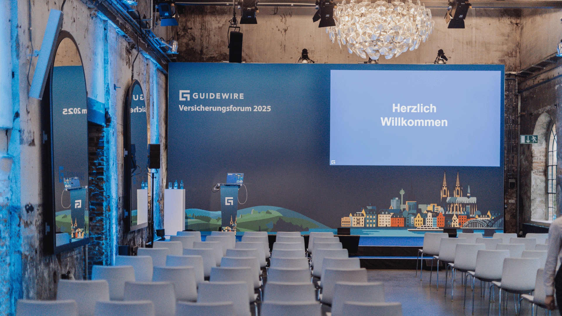 Guidewire Versicherungsforum 2025 im Harbour Club Köln – moderne Tagungslocation mit Bühne und Sitzreihen.